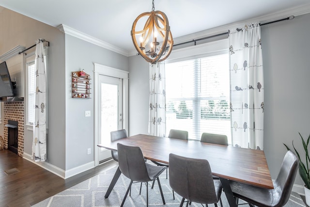 dining space featuring a chandelier, wood finished floors, baseboards, and ornamental molding