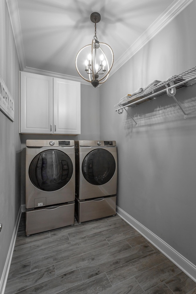 laundry room featuring crown molding, separate washer and dryer, a chandelier, cabinet space, and baseboards