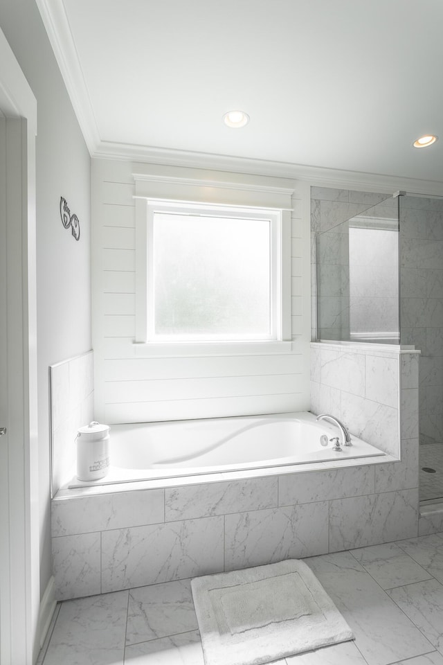 bathroom featuring a bath, marble finish floor, ornamental molding, and tiled shower