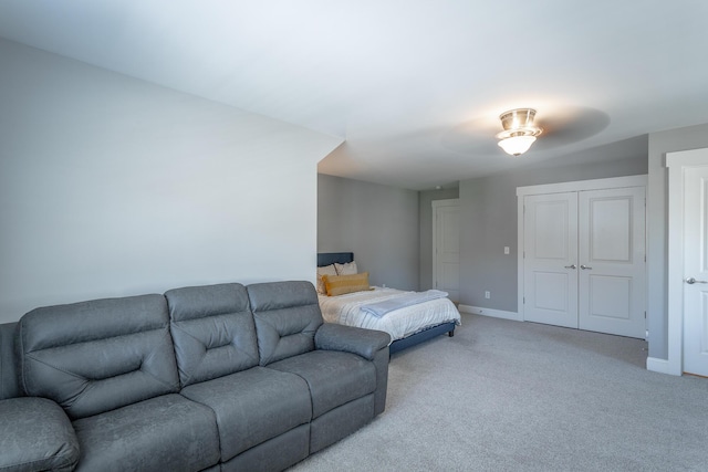 bedroom with light colored carpet, baseboards, and a closet