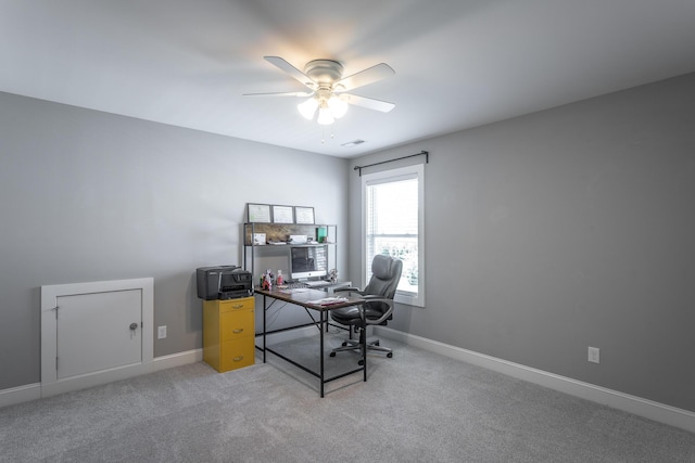office space with light carpet, baseboards, ceiling fan, and visible vents