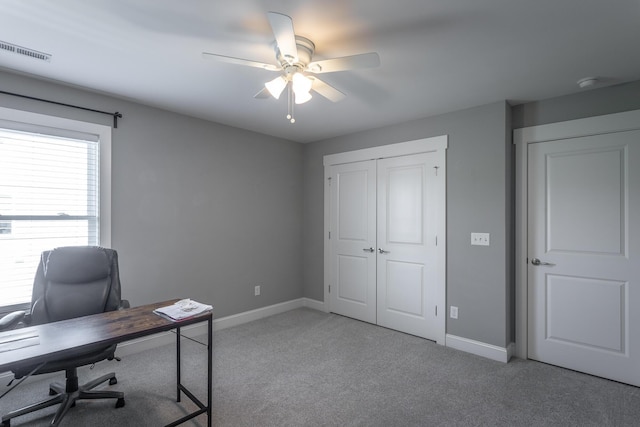 home office featuring ceiling fan, light carpet, visible vents, and baseboards