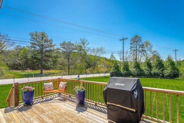 deck with a fenced backyard, grilling area, and a lawn