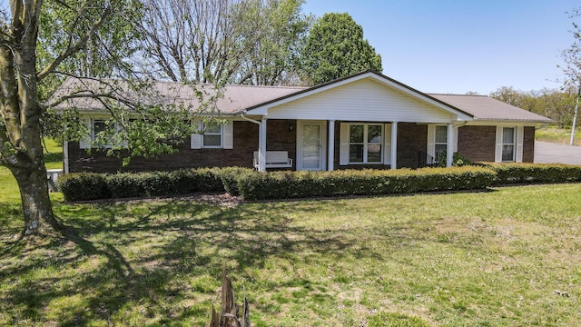 ranch-style house with brick siding, a front yard, and covered porch