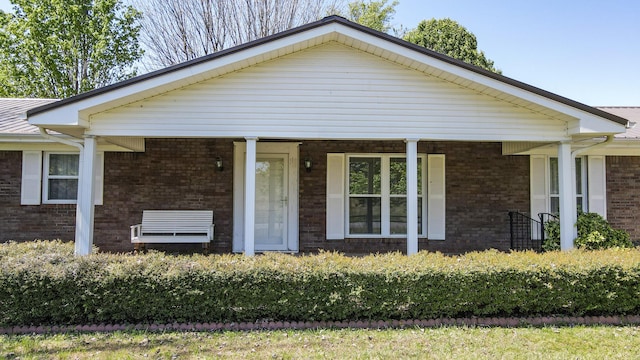 view of front of home with a porch and brick siding