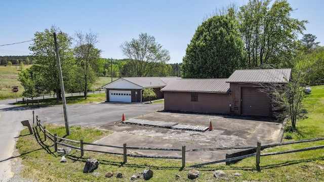 ranch-style house with fence, a garage, concrete block siding, and metal roof