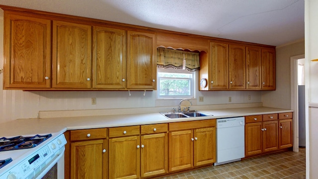 kitchen featuring brown cabinetry, light countertops, white appliances, and a sink