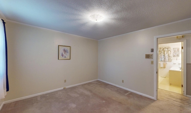 carpeted empty room featuring baseboards, a textured ceiling, and crown molding