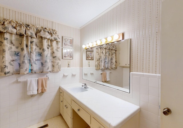 bathroom with wallpapered walls, tile walls, a wainscoted wall, and ornamental molding