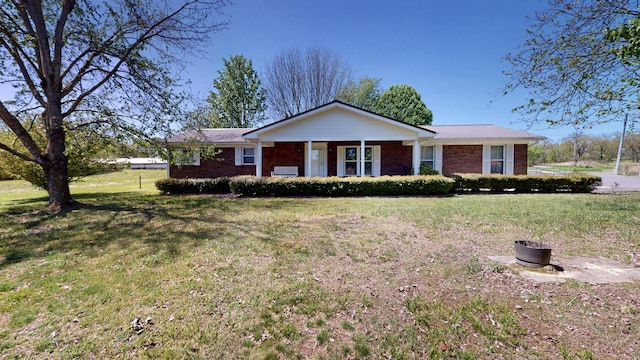 ranch-style house with brick siding, a porch, and a front yard