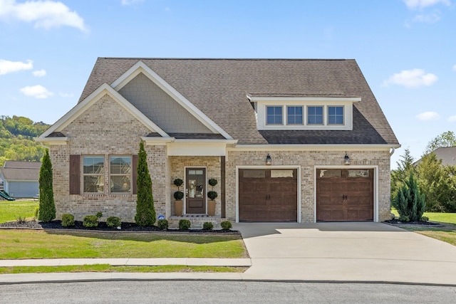 craftsman house with concrete driveway, roof with shingles, a front lawn, brick siding, and a garage