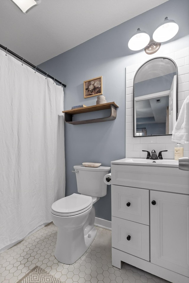 full bathroom with decorative backsplash, baseboards, toilet, tile patterned floors, and vanity