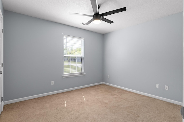 unfurnished room with a ceiling fan, visible vents, carpet, baseboards, and a textured ceiling