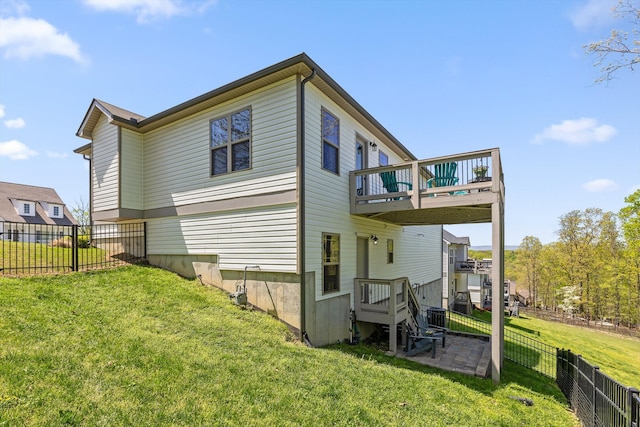 back of house featuring a yard, a fenced backyard, a wooden deck, and a patio