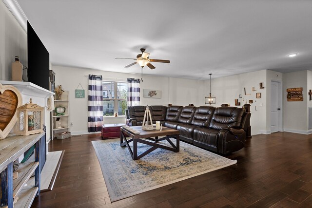 living area featuring visible vents, baseboards, a ceiling fan, and wood finished floors