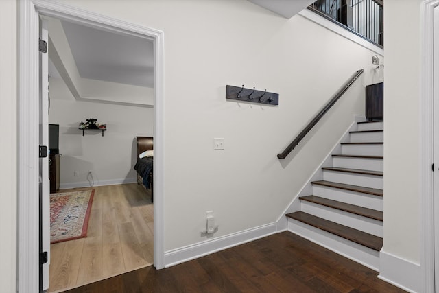 staircase featuring baseboards and wood finished floors