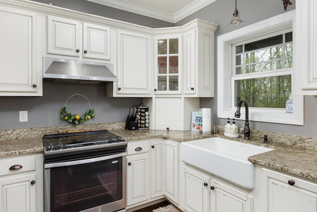 kitchen featuring exhaust hood, stainless steel range with electric cooktop, white cabinets, ornamental molding, and a sink