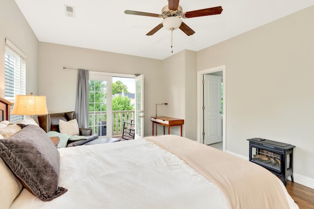 114 W 19th St, Chattanooga, TN 37408 - bedroom featuring wood finished floors, a wood stove, baseboards, visible vents, and access to outside