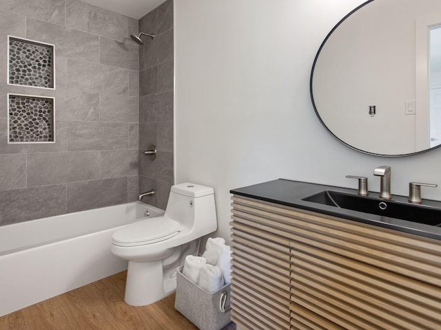 bathroom featuring toilet, shower / bathing tub combination, vanity, and wood finished floors