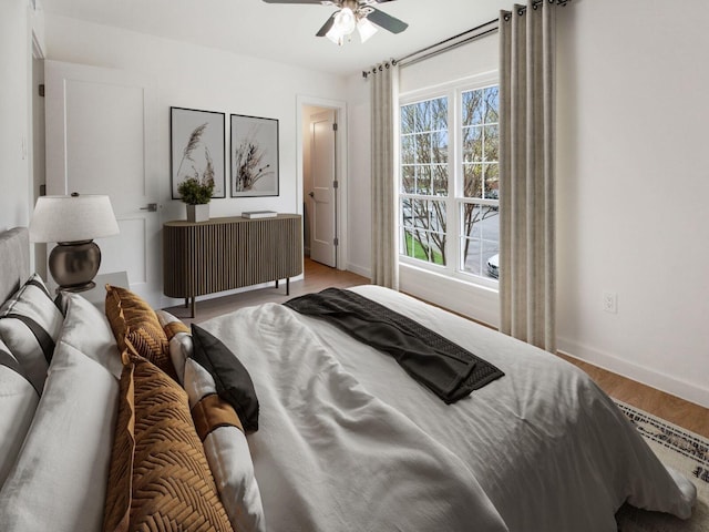 bedroom featuring wood finished floors, ceiling fan, and baseboards