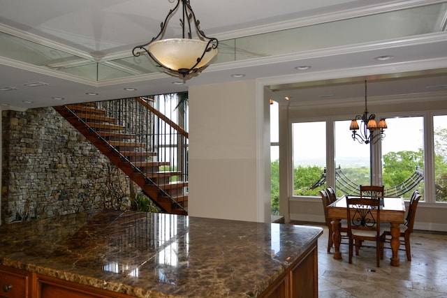 dining space featuring a chandelier, ornamental molding, and baseboards