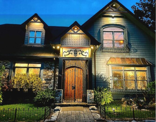 entrance to property with stone siding and fence