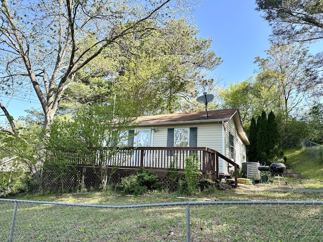 exterior space with central AC, a fenced backyard, and a deck