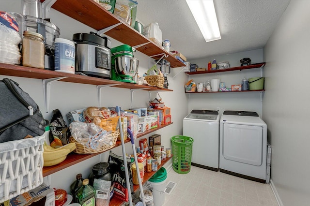 laundry area featuring separate washer and dryer, baseboards, a textured ceiling, and laundry area