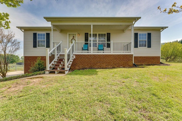view of front of house featuring stairway, a front yard, and covered porch