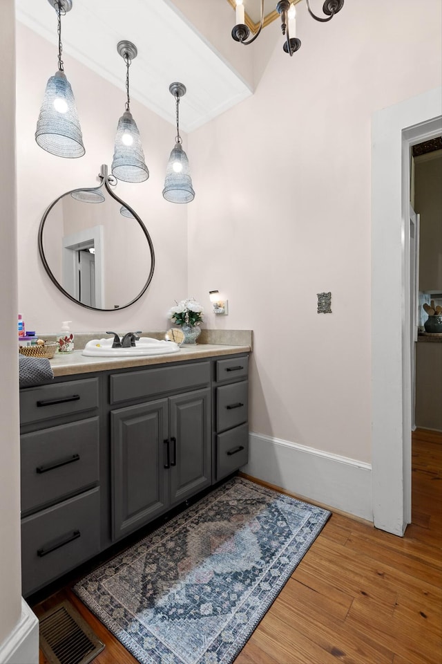 302 S Main St, Lafayette, GA 30728 - bathroom featuring wood finished floors, vanity, baseboards, a notable chandelier, and visible vents