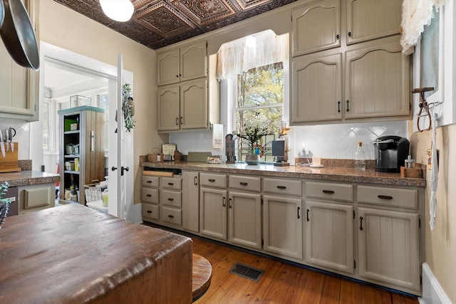 302 S Main St, Lafayette, GA 30728 - kitchen featuring hardwood / wood-style flooring, backsplash, dark countertops, and visible vents