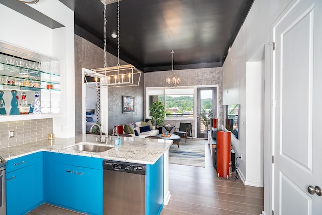 kitchen with a notable chandelier, a sink, dishwasher, open floor plan, and blue cabinets