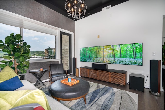 living area with a high ceiling, a notable chandelier, wood finished floors, and visible vents