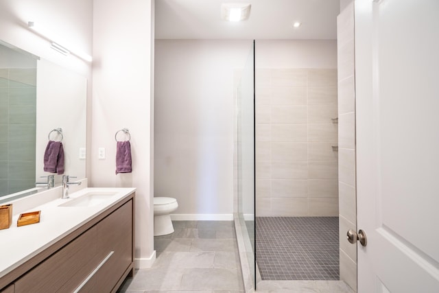 bathroom featuring vanity, baseboards, toilet, recessed lighting, and tiled shower