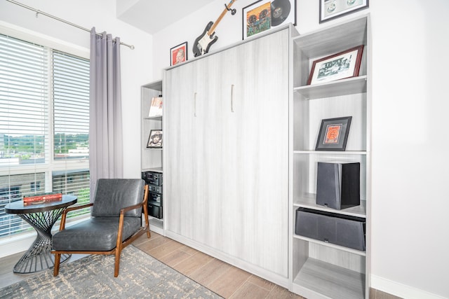 living area with baseboards and wood finished floors