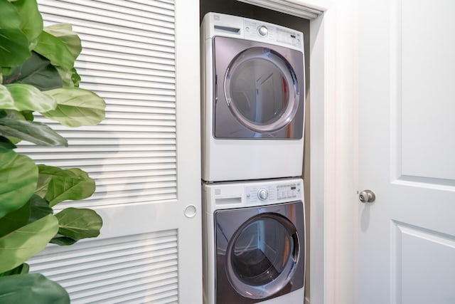 clothes washing area featuring stacked washer / drying machine and laundry area