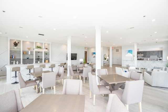dining space featuring recessed lighting, decorative columns, visible vents, and light wood-style floors