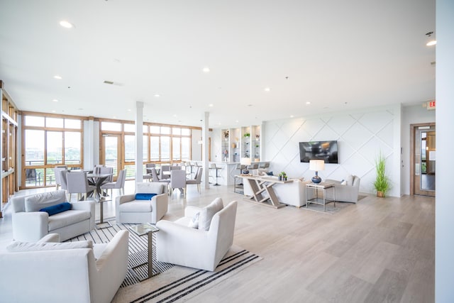 living room with recessed lighting, visible vents, expansive windows, and light wood-style floors