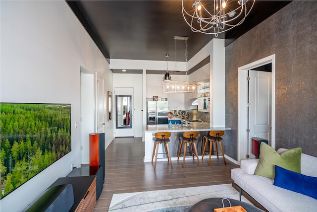 living area featuring baseboards, dark wood-style floors, and a chandelier