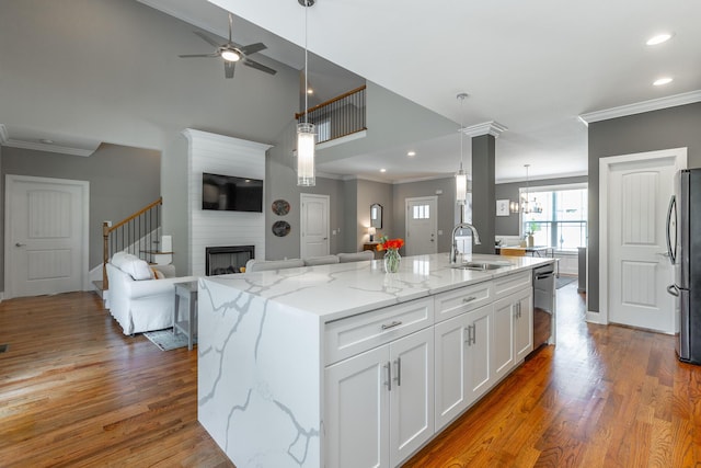kitchen featuring ornamental molding, open floor plan, and white cabinetry