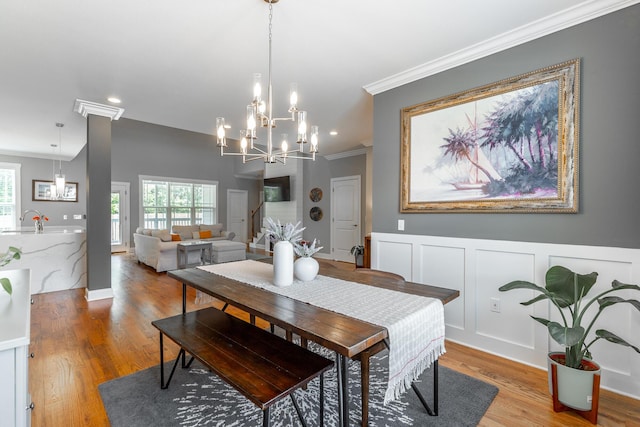 dining space with light wood finished floors, an inviting chandelier, recessed lighting, and ornamental molding