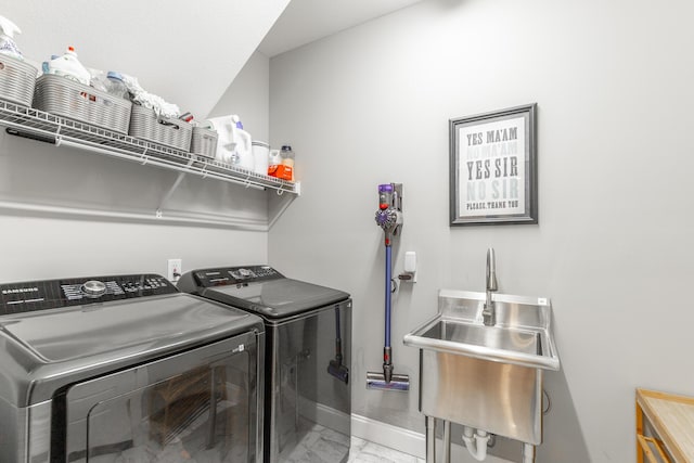 laundry room featuring washing machine and clothes dryer, a sink, baseboards, marble finish floor, and laundry area