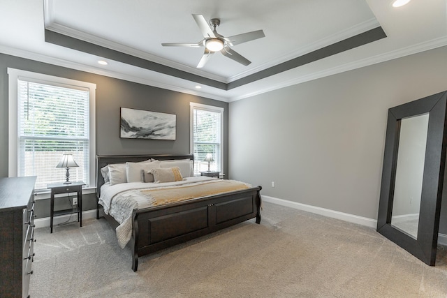bedroom with a ceiling fan, light carpet, a tray ceiling, baseboards, and ornamental molding
