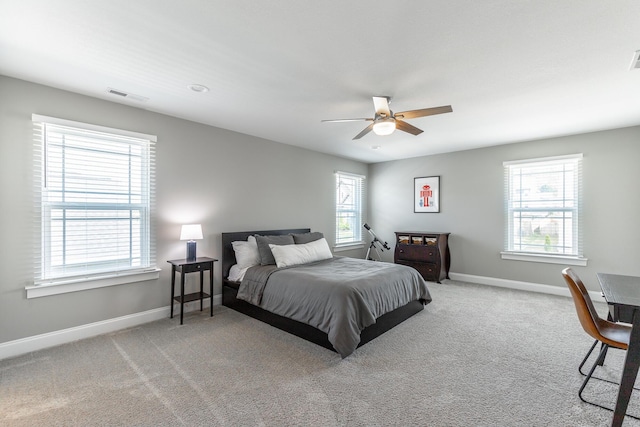 bedroom featuring baseboards, visible vents, light colored carpet, and ceiling fan