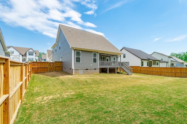 rear view of property featuring a fenced backyard, crawl space, stairs, and a lawn