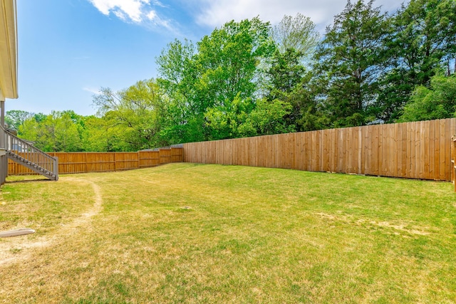 view of yard with stairway and a fenced backyard