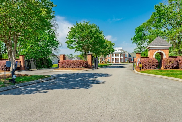 view of street with a gated entry and curbs