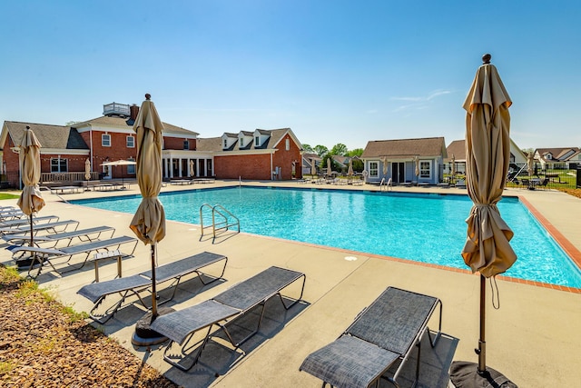 pool with a residential view and a patio