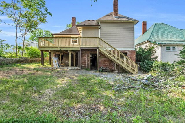 back of house with a wooden deck, stairs, a chimney, and brick siding