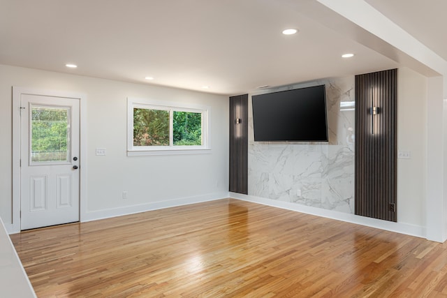 unfurnished living room with light wood finished floors, baseboards, plenty of natural light, and recessed lighting